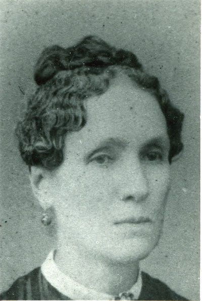 A black and white photo of a woman with curly hair.