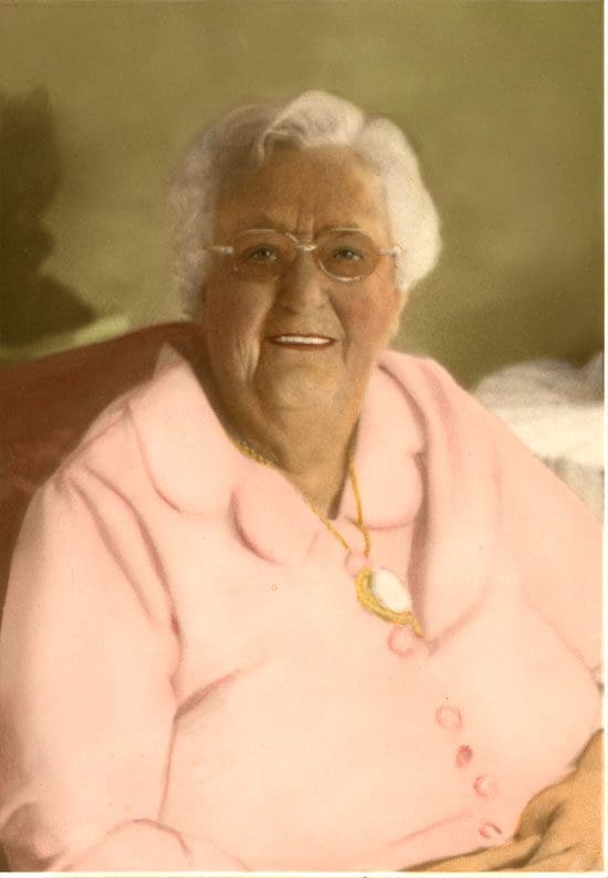 An old photo of an older woman in a pink shirt.