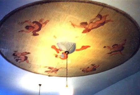 A ceiling with a painting of angels and cherubs.