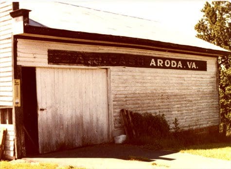 A white building with a sign on the side of it.