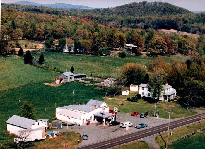 An aerial view of a rural area with buildings and cars.