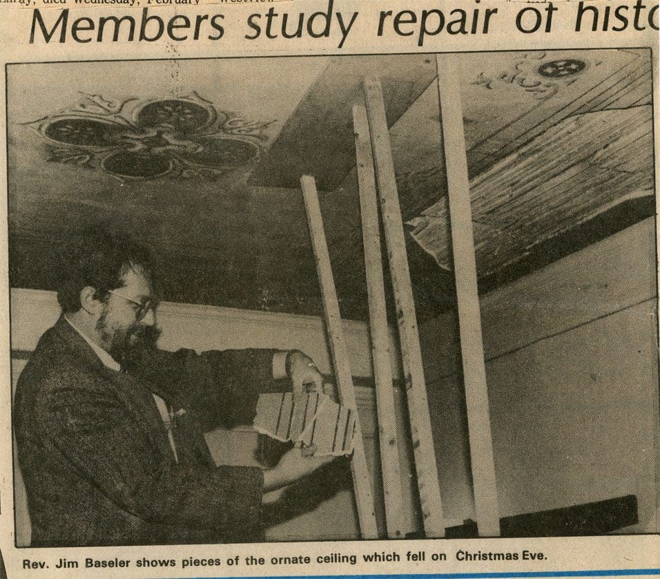 A newspaper clipping of an old photo with a man working on a ceiling.