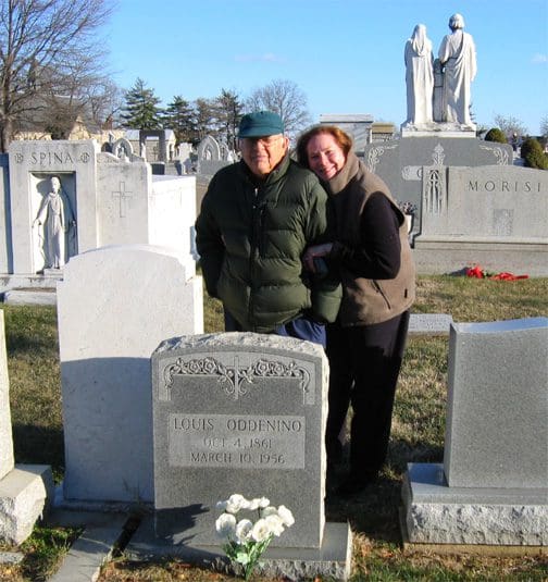 Two people standing in front of a grave