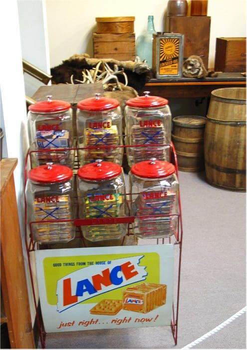 A display case with jars of candy on top.