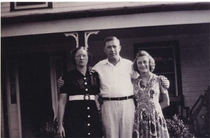 A black and white photo of two women and an older man.