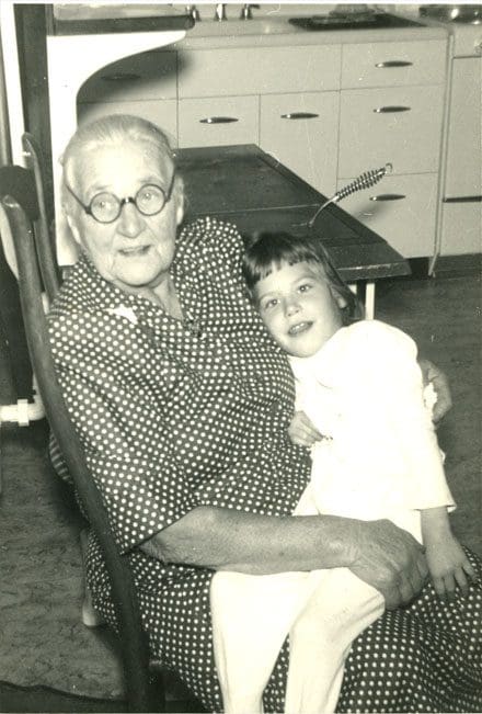 An old man sitting in a chair with a young boy.