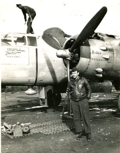 A man standing next to an airplane on the ground.