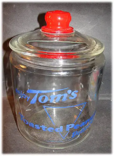 A clear glass container with a red lid.