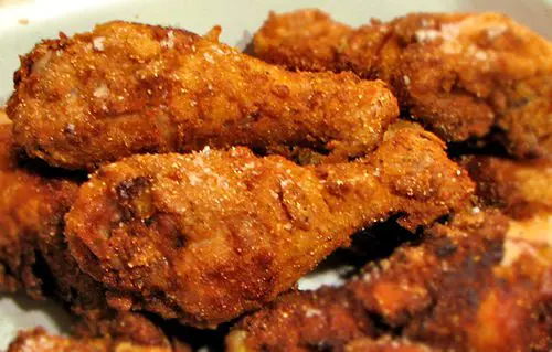 Fried chicken wings on a white plate.