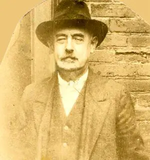 An old photo of a man in a suit and hat.