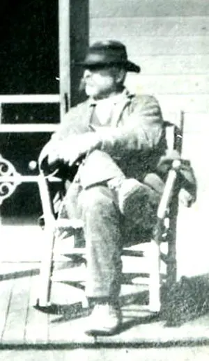 An old photo of a man sitting in a rocking chair.