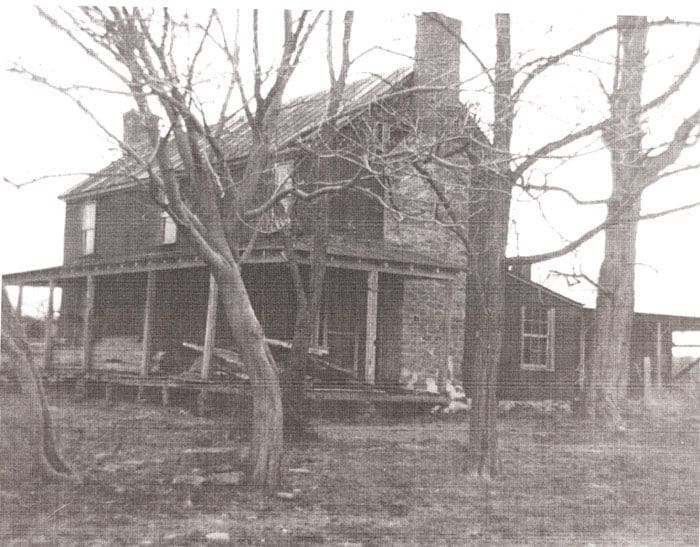 A black and white photo of an old house.