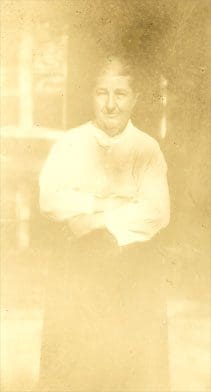 A man sitting on the ground in front of a window.