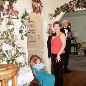 A woman and child standing in front of christmas decorations.