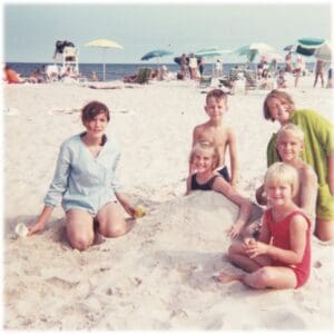 A group of people sitting on top of the beach.