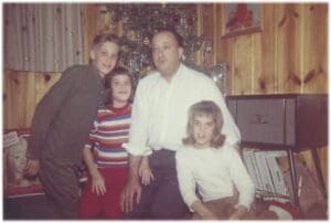 A man and two girls posing for the camera with another girl.