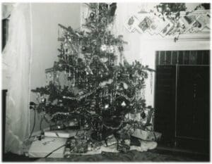 A christmas tree with decorations in the corner of a room.