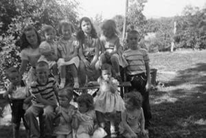 A group of children sitting on top of a wooden wagon.