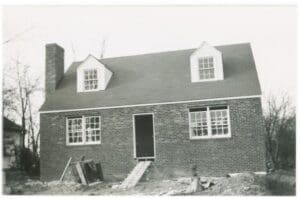 A black and white photo of a house under construction.