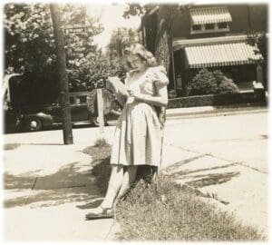 A woman standing on the side of a road.