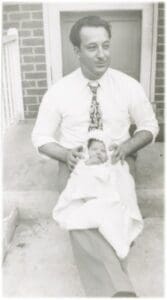 A man sitting on the ground with a baby.