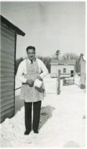 A man standing in the snow holding something.