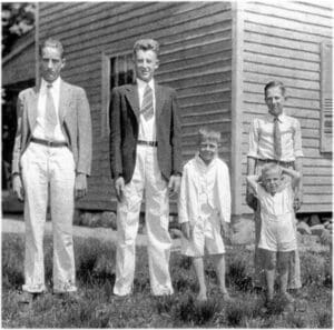 A group of men standing in front of a house.