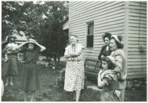 A group of people standing in front of a house.