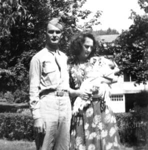 A man and woman standing in front of a house.